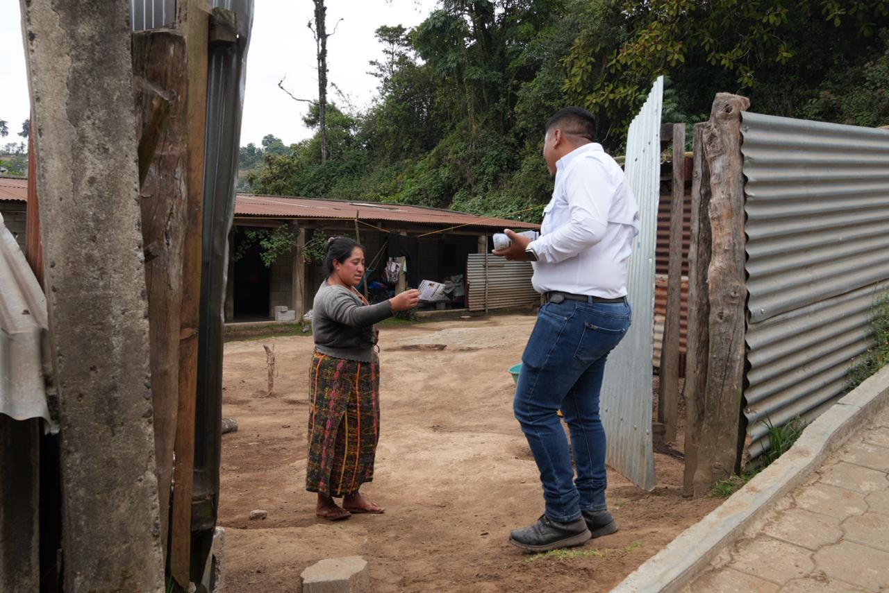 Colaborador entregando información puerta a puerta en la comunidad